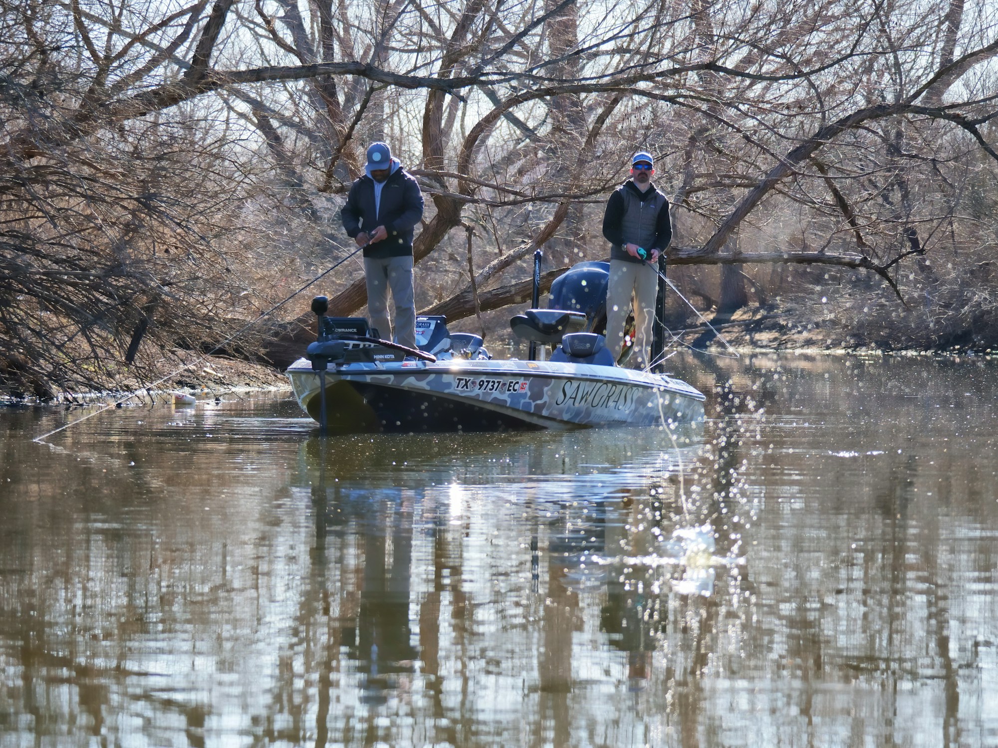 Двое спиннингистов ловят хищника с лодки на большом водохранилище